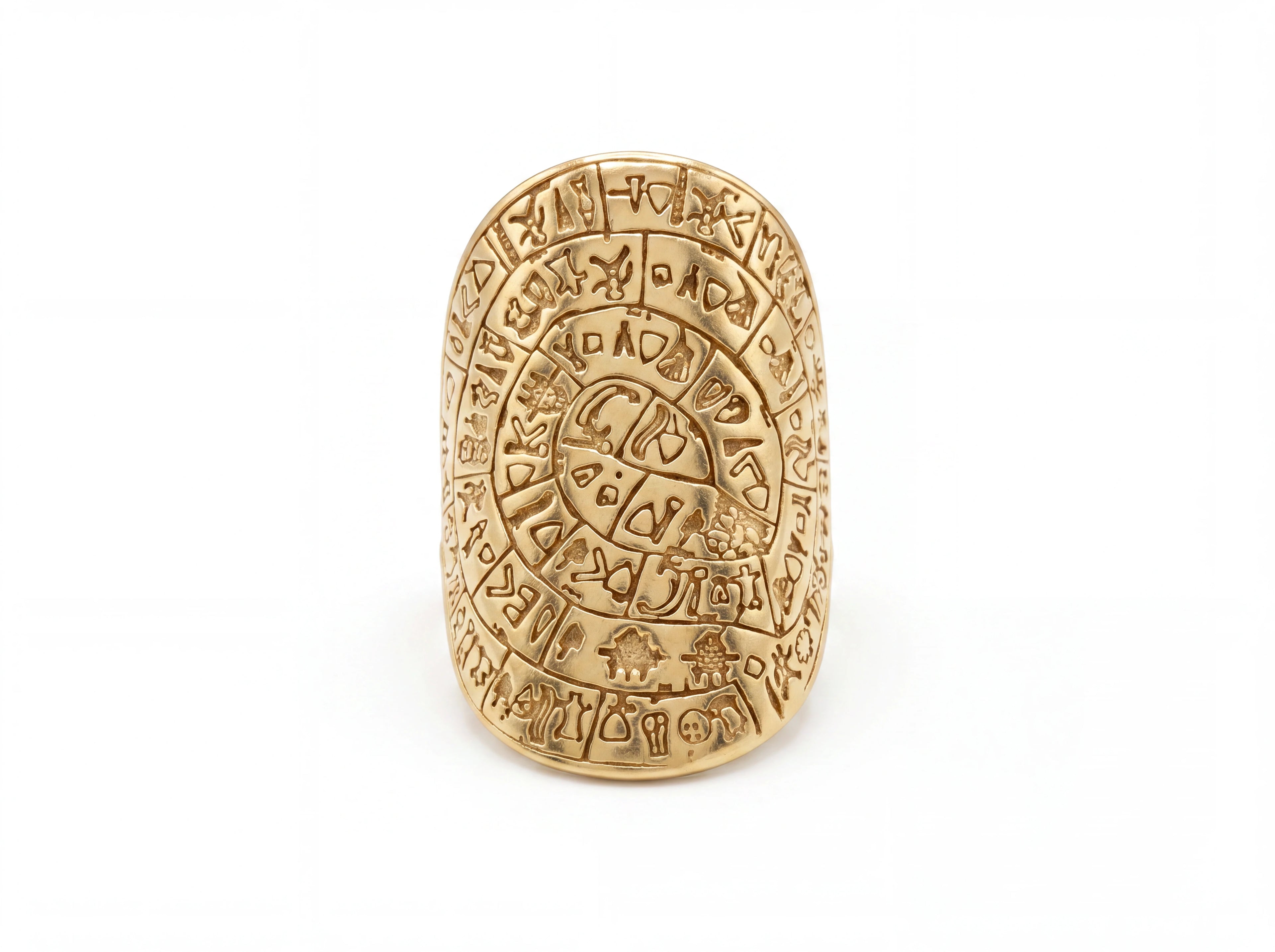 A gold-toned Aztec calendar ring featuring intricate engravings and glyphs, photographed on a clean white background.